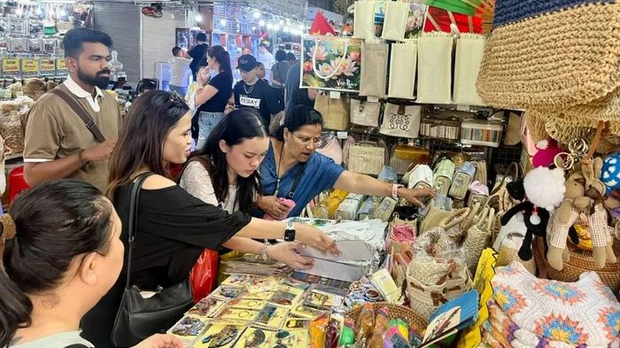 Du khách quốc tế chọn mua đồ lưu niệm tại chợ Bến Thành, TPHCM