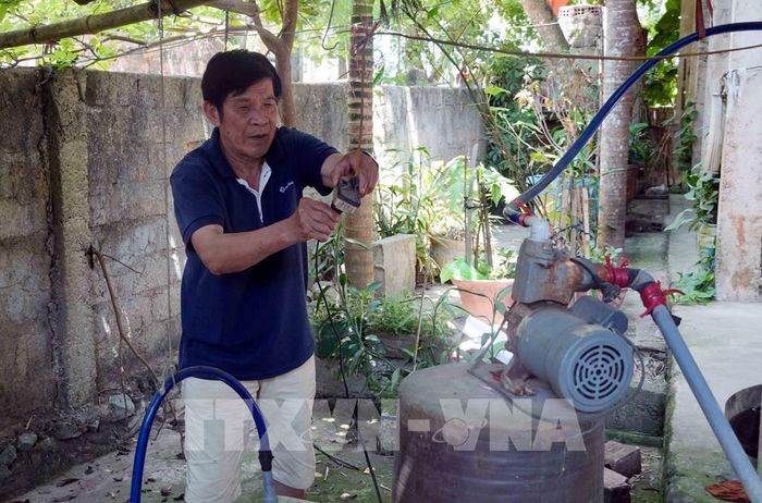 Nhiều hộ dân xã Tân Gianh (Quảng Trị) sử dụng máy để bơm nước nhiễm phèn phục vụ cho việc sinh hoạt vào mùa hè. Ảnh: Tá Chuyên - TTXVN