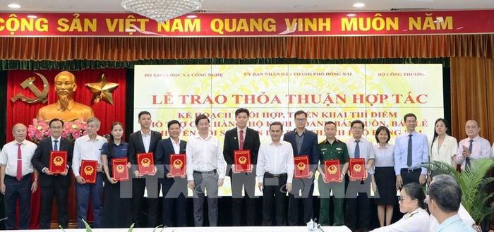 Trao thỏa thuận hợp tác giữa các đơn vị thí điểm hỗ trợ cửa hàng, hộ kinh doanh bán buôn, bán lẻ chuyển đổi số trên địa bàn thành phố Đồng Nai giữa các cơ quan, đơn vị. Ảnh: Sỹ Tuyên - TTXVN