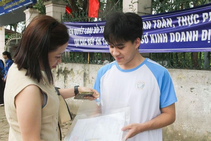 Phụ huynh và thí sinh dự thi tại điểm thi Trường THCS Phúc Diễn kiểm tra giấy tờ trước giờ làm thủ tục đăng ký dự thi.