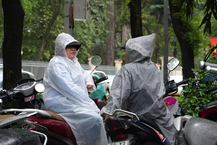 Những người mẹ đội mưa đợi con ngoài cổng trường.