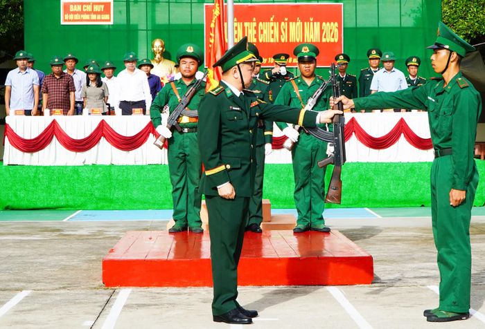 Đại tá Trần Ngọc Châu, Phó Chỉ huy trưởng, Tham mưu trưởng Ban Chỉ huy Bộ đội Biên phòng tỉnh An Giang trao vũ khí cho chiến sĩ mới.