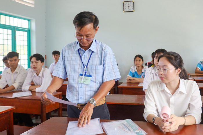 Cán bộ coi thi đối chiếu thông tin thí sinh.