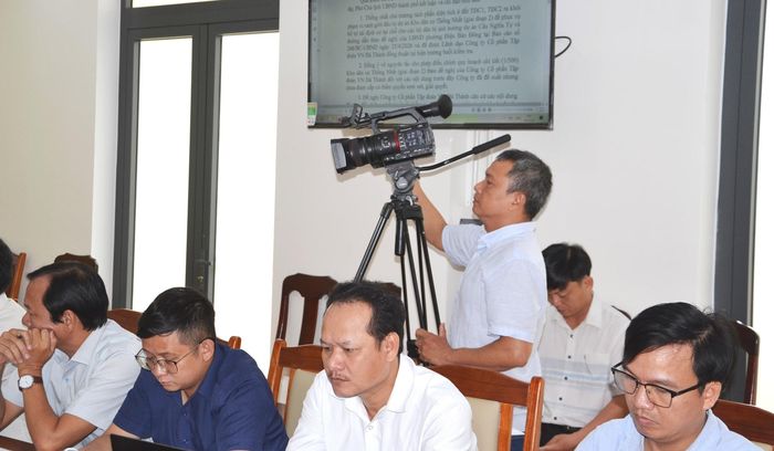 Kỹ thuật viên Trung tâm Cung ứng dịch vụ sự nghiệp công phường Điện Bàn Đông quay phim, đưa tin một cuộc họp liên quan đến giải phóng mặt bằng đường dẫn cầu Nghĩa Tự. Ảnh: CÔNG TÚ