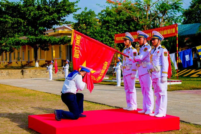 Chiến sĩ mới thực hiện nghi thức hôn Quân kỳ Quyết thắng. Ảnh: BẢO LÂM