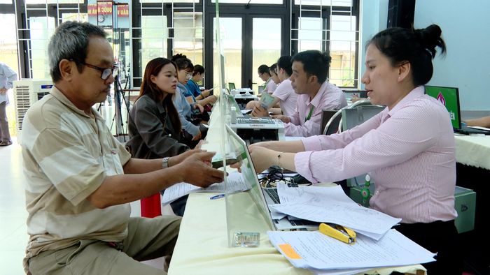 Người dân nhận tiền vay tại điểm giao dịch Chính Gián, phường Thanh Khê. Ảnh: DIỄM HƯƠNG - TRƯỜNG SƠN