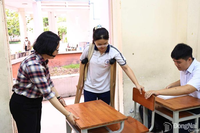 Một thí sinh của Trường THPT chuyên Lương Thế Vinh bị đau chân, được ưu tiên ngồi bàn đầu trong buổi làm thủ tục. Ảnh: CN