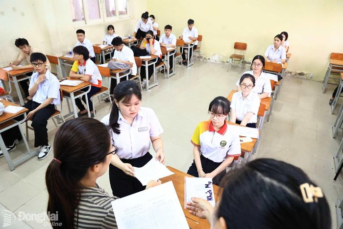 Giám thị đối chiếu rà soát thông tin ghi trên thẻ dự thi của thí sinh tại điểm thi Trường THPT chuyên Lương Thế Vinh. Ảnh: CN