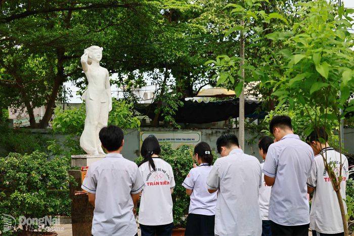 Tranh thủ đến sớm, thí sinh Trường THPT Trấn Biên dâng hương tưởng nhớ Anh hùng liệt sĩ Võ Thị Sáu trong khuôn viên trường. Đây cũng là nét đẹp của học sinh nhà trường suốt nhiều năm qua Ảnh: CN