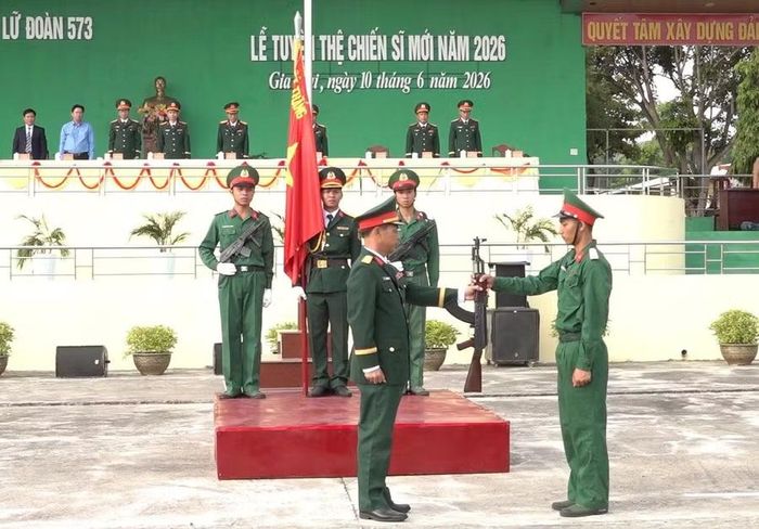  Chỉ huy Lữ đoàn 573 thực hiện nghi thức trao súng cho CSM. Ảnh: Minh Lâm 