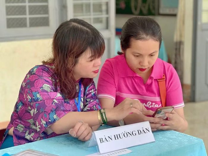 Giáo viên trực tiếp hướng dẫn phụ huynh thao tác đăng ký, hoàn thiện hồ sơ điện tử. Ảnh: T.D