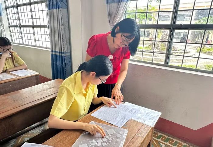 Cán bộ coi thi hướng dẫn thí sinh kiểm tra thông tin tại điểm thi Trường THPT số 2 Quang Trung (phường An Khê). Ảnh: Minh Chí