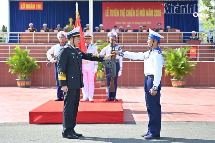 Thủ trưởng lữ đoàn thực hiện nghi thức trao vũ khí cho chiến sĩ mới.