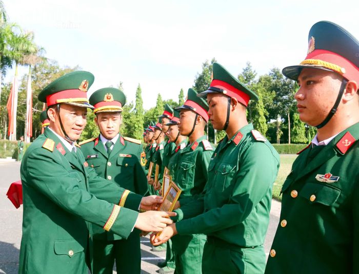Đại tá Phạm Văn Chuyên - Phó Bí thư Đảng ủy, Lữ đoàn trưởng Lữ đoàn 293 trao giấy khen cho chiến sĩ mới.