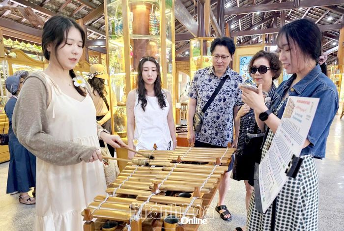 Du khách trải nghiệm chơi nhạc cụ dân tộc tại Làng nghề Trường Sơn, phường Nam Nha Trang, tỉnh Khánh Hòa.