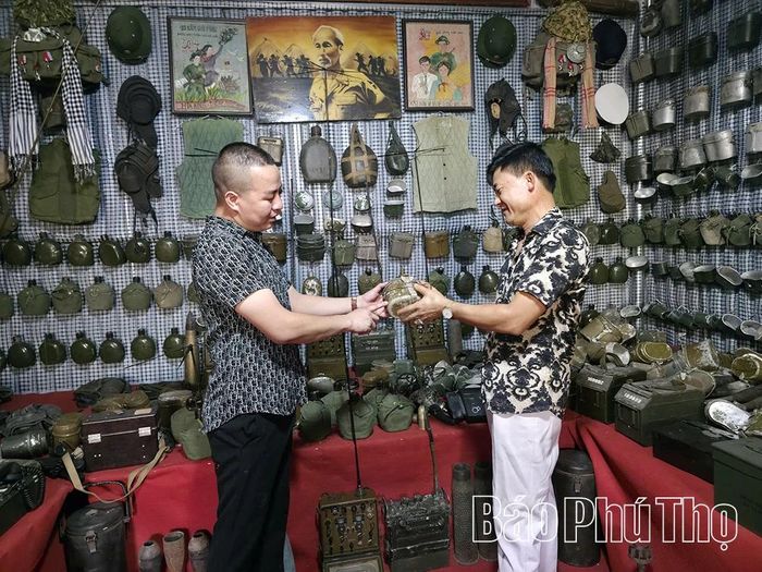 Anh Thập giới thiệu với khách tham quan những kỷ vật chiến tranh mà anh sưu tầm .