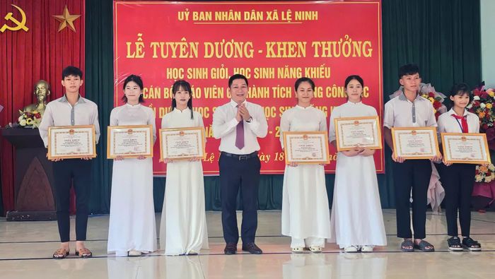 Đại diện lãnh đạo xã Lệ Ninh tặng giấy khen cho các học sinh đạt thành tích cao trong năm học 2025-2026 - Ảnh: L.Chi