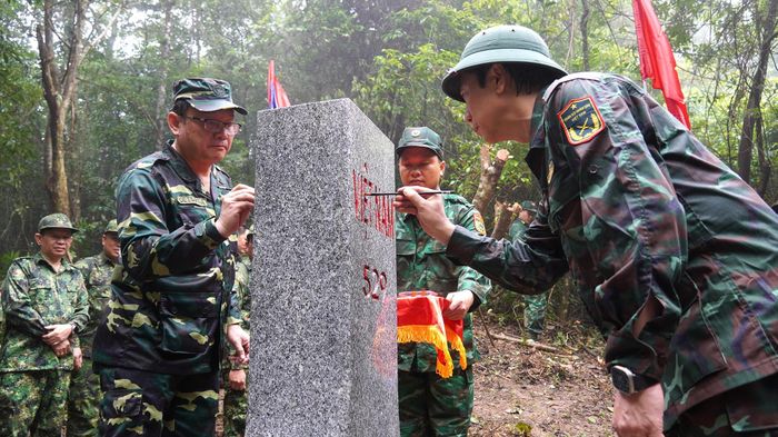 Lãnh đạo hai tỉnh sơn lại mốc quốc giới - Ảnh: C.H