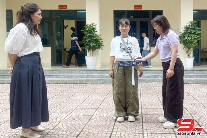 Cán bộ điểm thi kiểm tra thiết bị quét an ninh cầm tay.