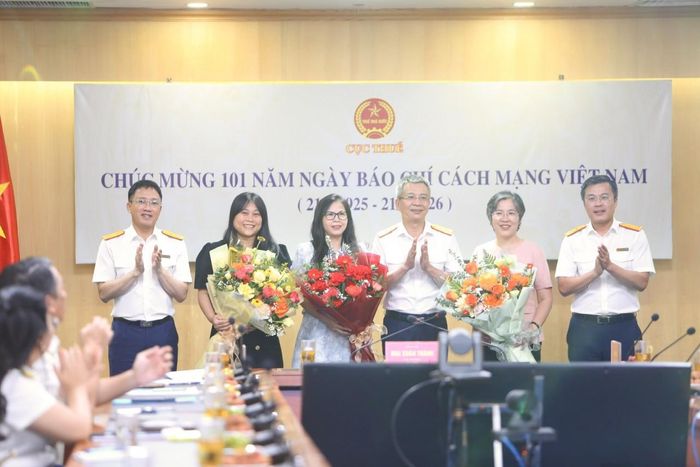 Lãnh đạo Cục Thuế tặng hoa chúc mừng các nhà báo. Ảnh: Đức Minh