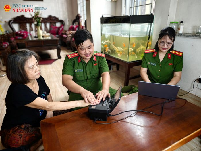 Bên cạnh chiếc máy thu nhận dữ liệu dân cư là những bàn tay ân cần nâng đỡ người già.