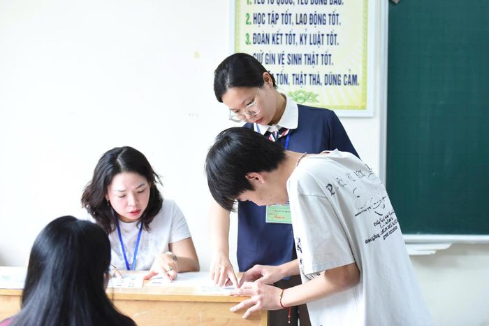 Thí sinh rà soát giấy tờ, số báo danh và phòng thi. Ảnh: Xuân Quý