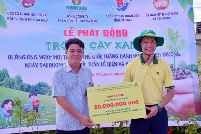 Bí thư Đoàn Thanh niên PVCFC Nguyễn Văn Tú trao tặng kinh phí cho công trình cây xanh. Ảnh: PVCFC