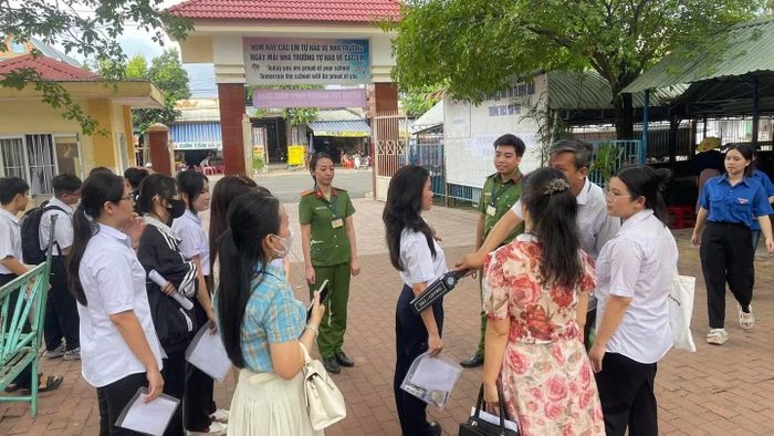 Công an phường Bình Phước và Hội đồng coi thi hướng dẫn các thí sinh thực hiện việc kiểm tra an ninh, rà quét vật cấm bằng thiết bị chuyên dụng trước khi vào phòng thi tại Điểm thi số 70 - Trường THCS Tân Phú.
