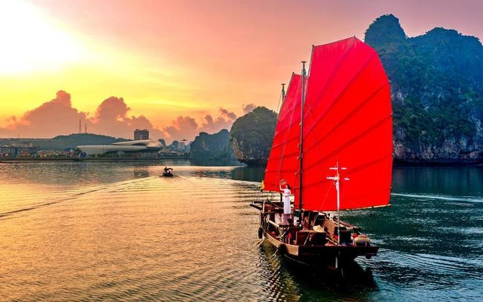 Được chế tác từ nguyên mẫu "thuyền ba vát" cổ vùng biển Quảng Ninh, những cánh buồm đỏ mang dáng vẻ cổ kính, hòa cùng nhịp điệu gió nước, tạo nên hiệu ứng thị giác giàu xúc cảm, khắc họa ký ức đời sống cư dân miền biển xưa. Qua đó kết nối du khách với văn hóa bản địa lâu đời của vùng di sản. Ảnh: Báo Thanh Niên