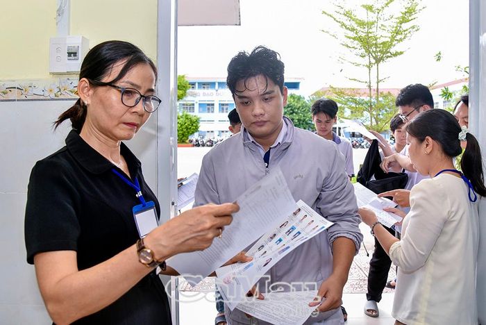 Cán bộ coi thi hướng dẫn thí sinh làm thủ tục vào phòng thi để nghe phổ biến quy chế.
