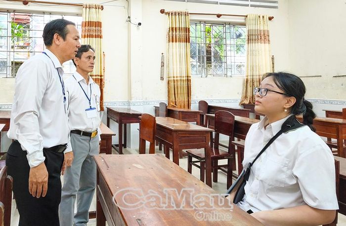 Thầy Huỳnh Hữu Vinh, Phó Trưởng Điểm thi số 003, Phó Hiệu trưởng Trường THPT Cà Mau (bìa trái), đến thăm hỏi, động viên và phổ biến quy chế thi cho em Thư trong ngày làm thủ tục dự thi.