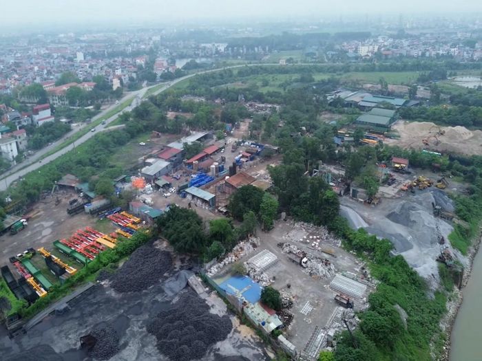 Toàn cảnh khu vực Bãi Đầm (thôn Cống Thôn, xã Phù Đổng, Hà Nội) ghi nhận qua khảo sát thực tế. Nhiều diện tích đất nông nghiệp ven sông xuất hiện các bãi tập kết vật liệu xây dựng, kho bãi, máy móc cơ giới và công trình phụ trợ, làm thay đổi hiện trạng sử dụng đất của khu vực. Ảnh PV.