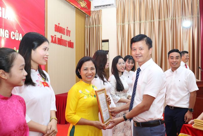 Phó Bí thư thường trực Đảng ủy xã Hồng Vân Nguyễn Tuấn Đạt trao giải Nhất cuộc thi cho đồng chí Nguyễn Thị Hậu, Trung tâm dịch vụ tổng hợp xã Hồng Vân. Ảnh: Vũ Cường.