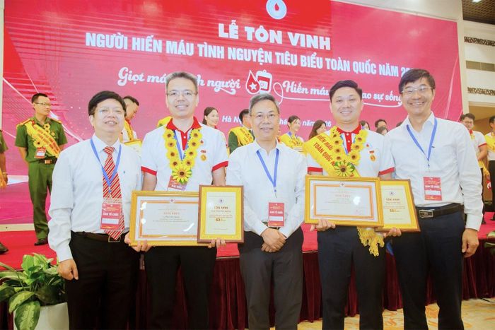 ThS. Phan Hữu Quang (thứ hai bên trái) và BSCKII. Vũ Hải Toàn (thứ hai bên phải) chụp ảnh với Lãnh đạo Bộ Y tế và Viện Huyết học - Truyền máu Trung ương tại Lễ tôn vinh người hiến máu tình nguyện tiêu biểu toàn quốc năm 2026. Ảnh: BVCC
