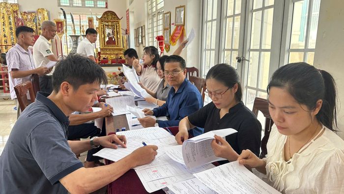 Người dân thôn Nhuệ Giang hoàn thiện thủ tục pháp lý trước khi nhận tiền chi trả bồi thường GPMB. Ảnh: PV