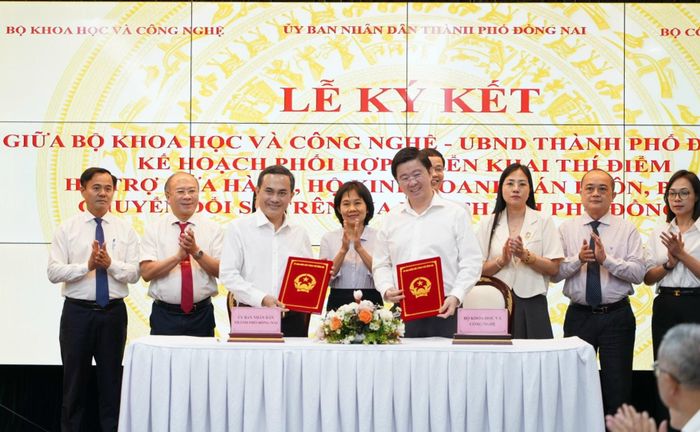 Thứ trưởng Bùi Hoàng Phương và Phó Chủ tịch UBND thành phố Đồng Nai Lê Trường Sơn trao Thỏa thuận hợp tác Kế hoạch phối hợp, triển khai thí điểm hỗ trợ cửa hàng, hộ kinh doanh bán buôn, bán lẻ chuyển đổi số trên địa bàn thành phố Đồng Nai. Ảnh: PV