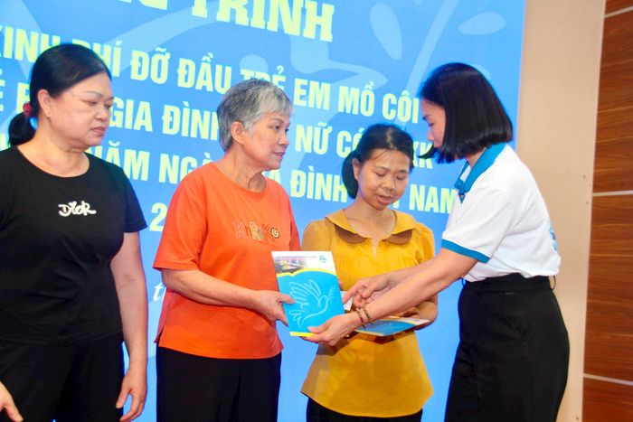 Chủ tịch Hội LHPN phường Phú Thượng Đỗ Thị Phương Lân trao thẻ bảo hiểm y tế cho hội viên phụ nữ khó khăn. Ảnh: Hoàng Vũ