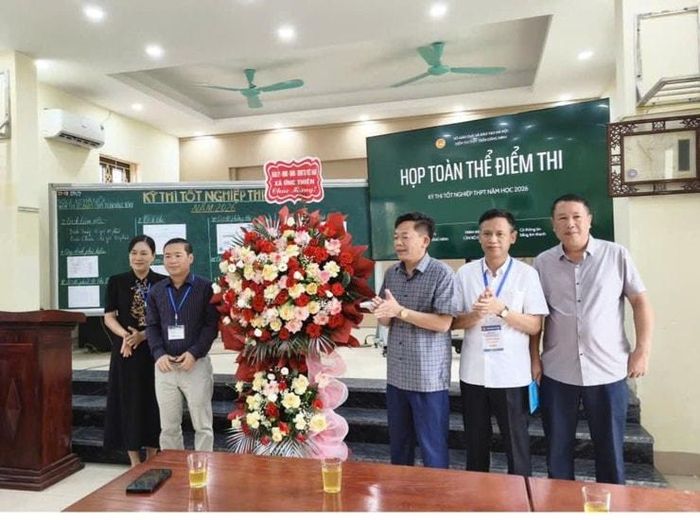 Lãnh đạo xã Ứng Thiên tặng hoa chúc các cán bộ làm công tác thi tại điểm thi Trường THPT Trần Đăng Ninh. Ảnh: Đoàn Thanh