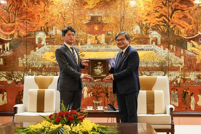 Phó Chủ tịch UBND thành phố Trương Việt Dũng (phải) trao quà lưu niệm của Thủ đô Hà Nội cho Thứ trưởng thứ hai Bộ Đất đai, Hạ tầng và Giao thông Hàn Quốc Hong Ji-seon. Ảnh: Hoàng Linh