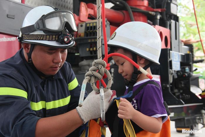 Trải nghiệm phương pháp hạ dây chậm, hỗ trợ thoát nạn từ trên cao của các bé trường Mầm non Hải Bối. Ảnh: PV