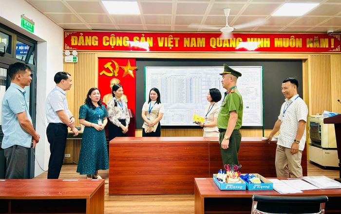 Đoàn công tác phường Hoàng Mai trao đổi với Trưởng điểm điểm thi Trường THPT Hoàng Văn Thụ về rà soát các điều kiện đảm bảo an toàn cho kỳ thi. Ảnh: Trần Oanh.