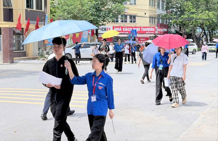 Tình nguyện viên hỗ trợ thí sinh tại điểm thi Trường THPT Tây Hồ trong ngày làm thủ tục thi. Ảnh: Cao Kỳ