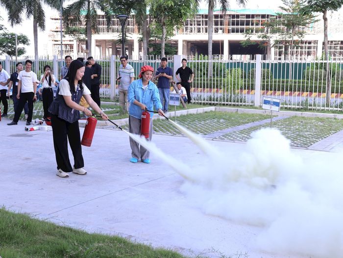 Người dân và cán bộ, công nhân viên chức các doanh nghiệp được trực tiếp thực hành sử dụng bình chữa cháy, mặt nạ phòng độc và kỹ năng thoát nạn trong môi trường nhiều khói khí độc. Ảnh: PV