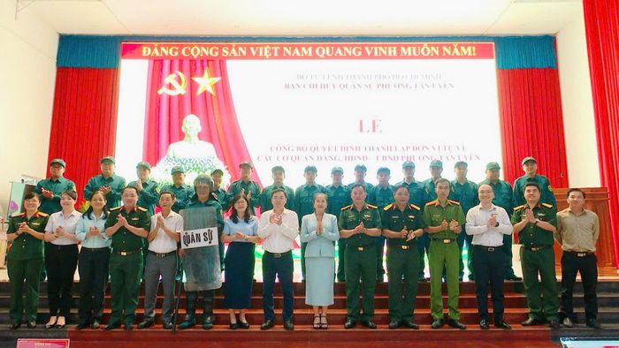  Các đại biểu chụp ảnh lưu niệm cùng lực lượng tự vệ mới thành lập sau lễ công bố quyết định, ghi dấu bước phát triển mới trong công tác xây dựng lực lượng tại địa phương. Ảnh: XUÂN MINH 