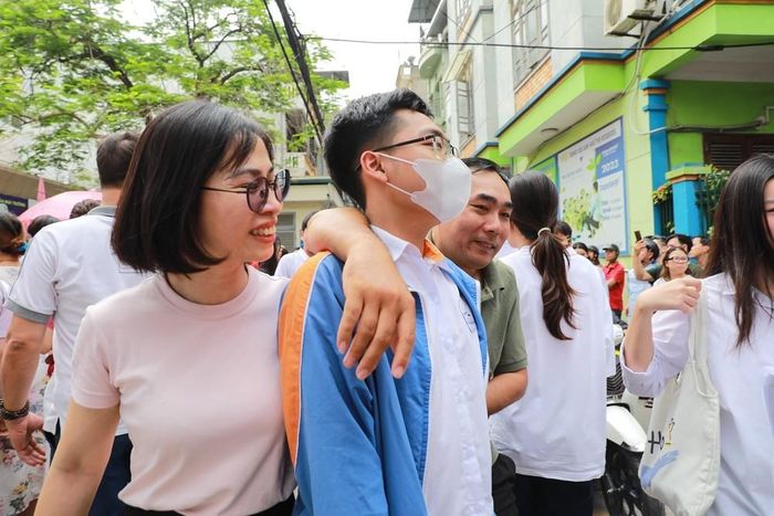 Phụ huynh chia sẻ cảm xúc với thí sinh sau khi hoàn thành môn thi đầu tiên tại điểm thi Trường THCS Ngô Quyền (phường Bạch Mai). Ảnh: Khánh Hòa - TTXVN