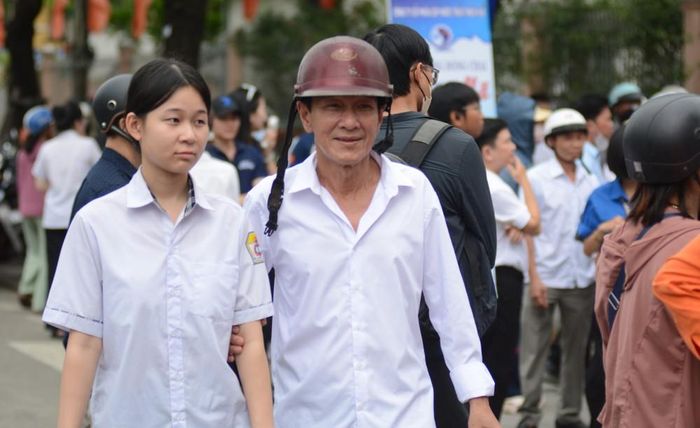 Thí sinh điểm thi trường THPT Cao Thắng (phường Thuận Hóa, thành phố Huế) được phụ huynh đón sau khi rời phòng thi. Ảnh: Văn Dũng-TTXVN