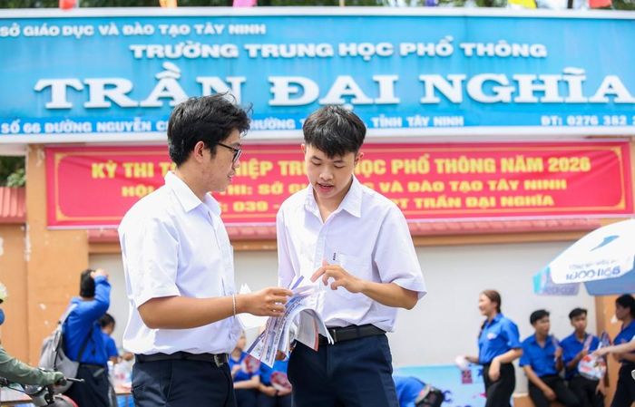 Em Nguyễn Thanh Bình (bên phải), học sinh Trường Trung học phổ thông Trần Đại Nghĩa và Lương Thành Danh (bên trái), học sinh Trường Trung học phổ thông Tây Ninh trao đổi sau khi hoàn thành môn thi. Ảnh: Giang Phương - TTXVN