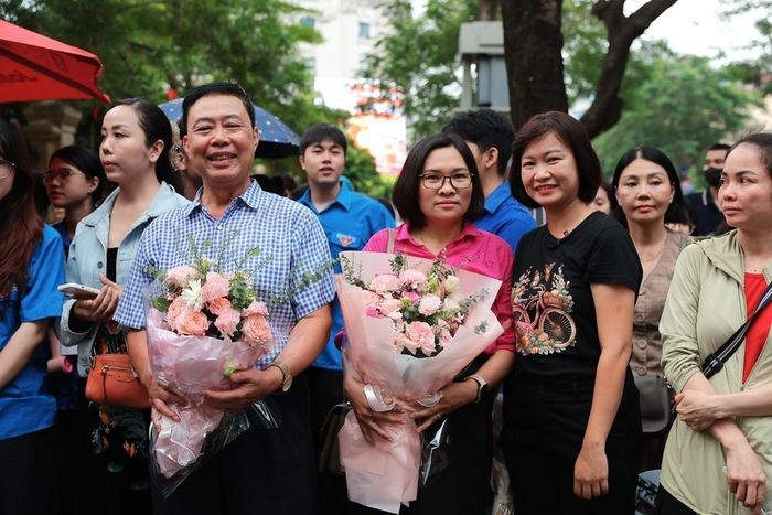 Các phụ huynh chuẩn bị hoa để tặng cho các thí sinh sau khi hoàn thành môn Toán Kỳ thi tốt nghiệp THPT. Ảnh: Phạm Tuấn Anh - TTXVN