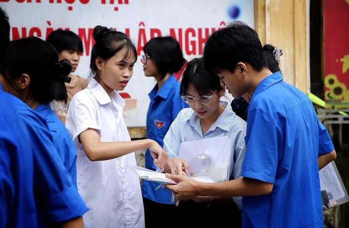 Các thi sinh trao đổi với thành viên Đoàn Thanh niên xã Đà Bắc, sau khi kết thúc môn Toán. Ảnh: Thanh Hải - TTXVN