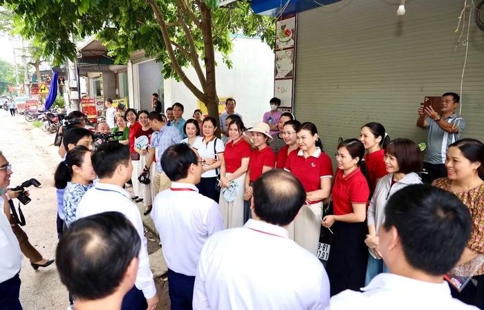 Bộ trưởng Giáo dục và Đào tạo Hoàng Minh Sơn trò chuyện với phụ huynh và giáo viên bên ngoài điểm thi Trường trung học phổ thông Kim Động (Hưng Yên) trước giờ làm bài môn Ngữ văn.